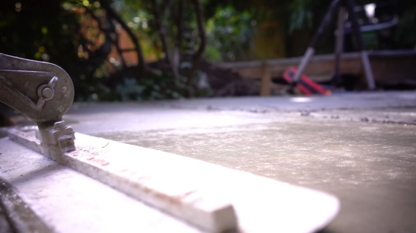 Concrete finishing tool leveling a fresh wet slab during installation in Laredo, TX